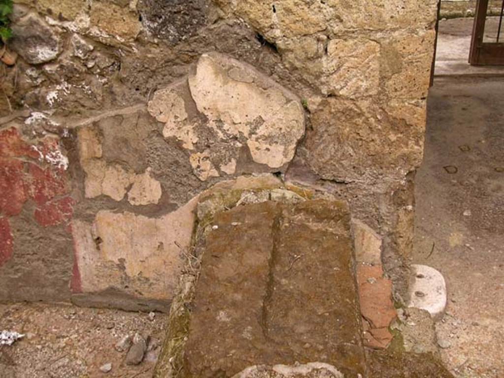 V.11, Herculaneum. May 2005. Base of steps against north wall of atrium, on west side of entrance corridor. 
Photo courtesy of Nicolas Monteix.